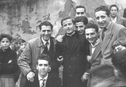 Don Berloffa e giovani sotto la lapide a Don Bosco