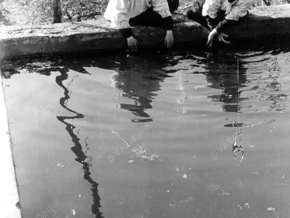 Due chierichetti, si specchiano nell'acqua