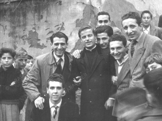 Don Berloffa e giovani sotto la lapide a Don Bosco